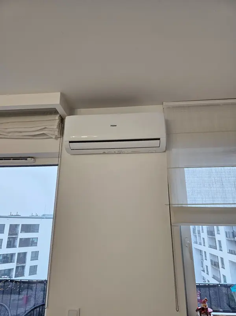 Technik montujący klimatyzator na ścianie